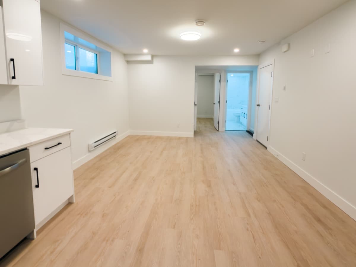 Open concept living area in completed basement suite