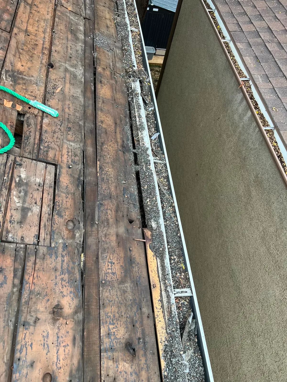 Rotted roof decking boards exposed during insurance restoration assessment