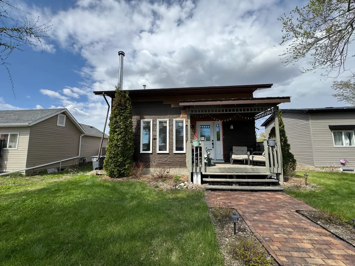 House with original dark weathered siding before full siding replacement in Saskatoon