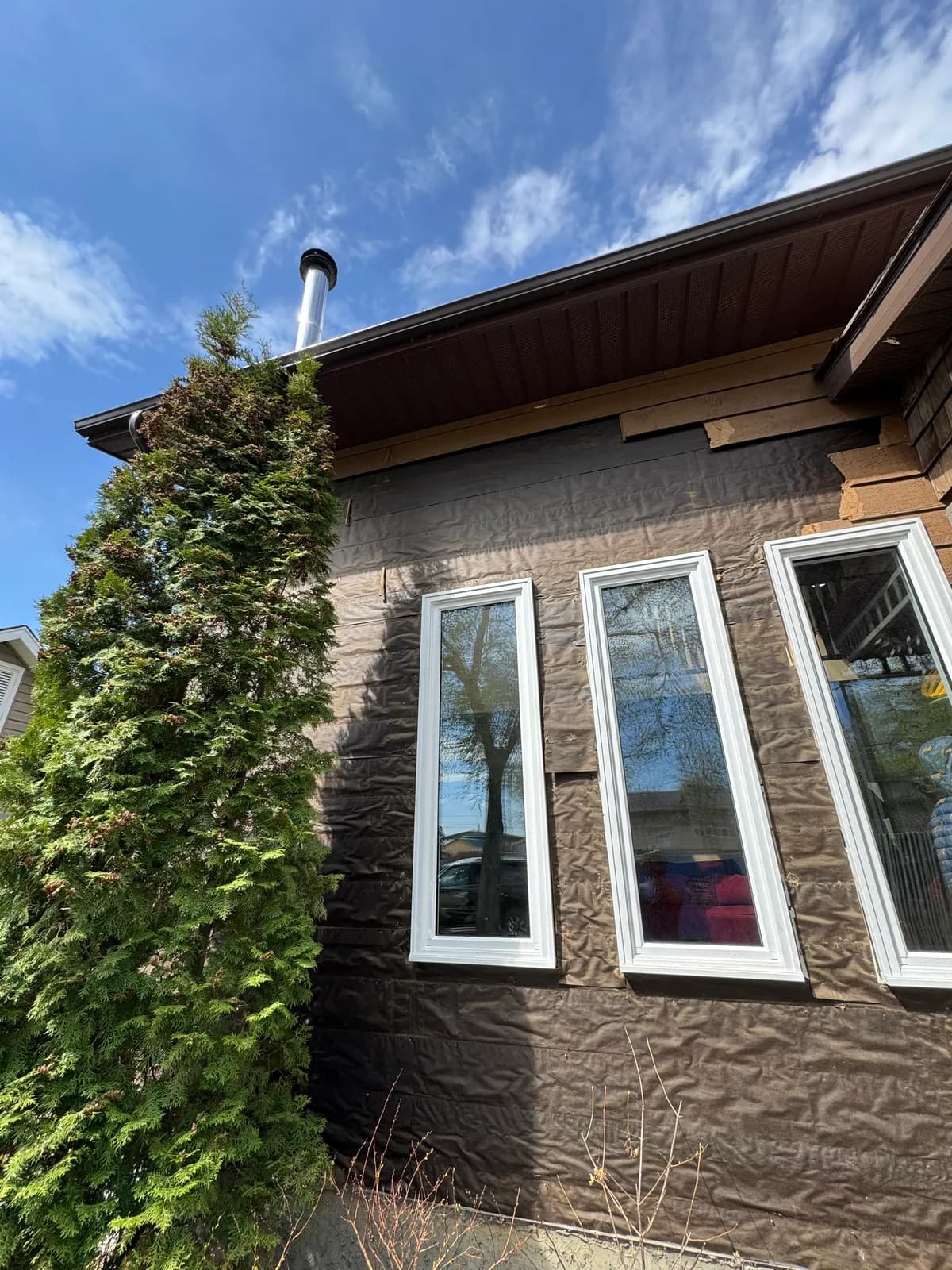 New windows sealed and flashed over building wrap during exterior renovation
