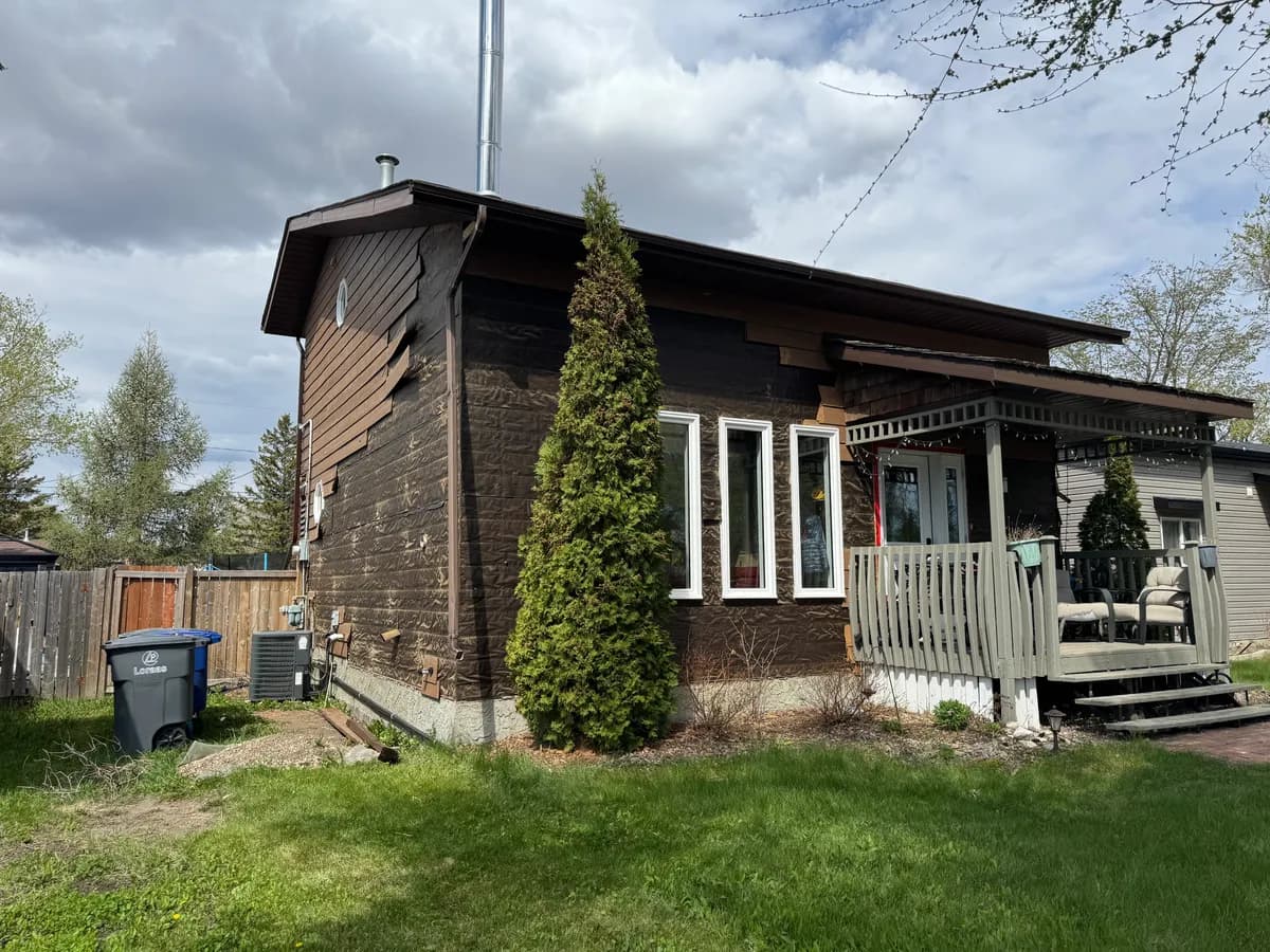 House front elevation with old siding removed down to building wrap before new siding installation