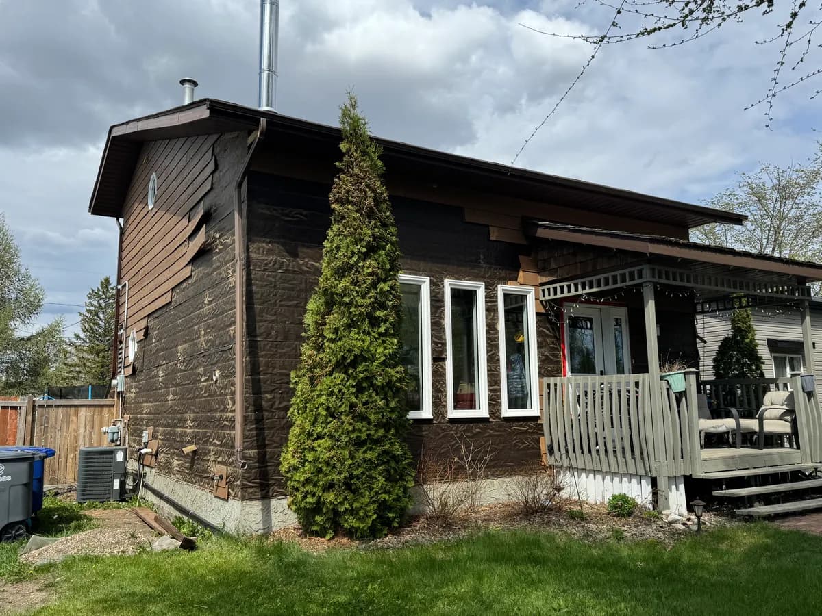 Corner of house stripped to weather barrier during full siding replacement in Saskatoon