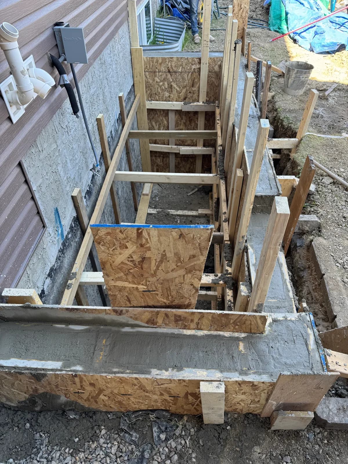 Foundation cut for new basement suite entrance executed from engineered drawings