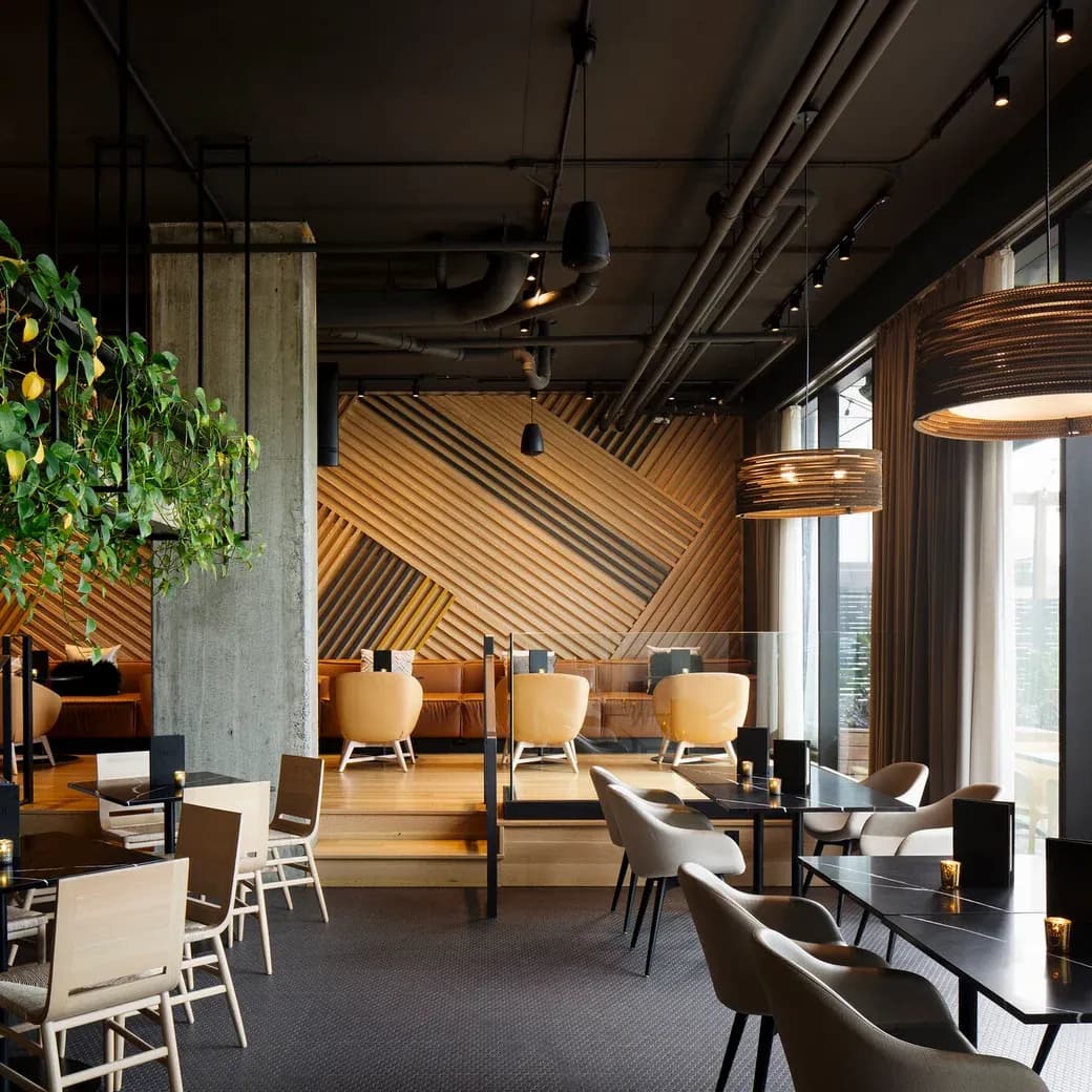 Finished lounge at Alt Hotel Saskatoon with wood-slat accent wall, leather banquette seating and pendant lighting