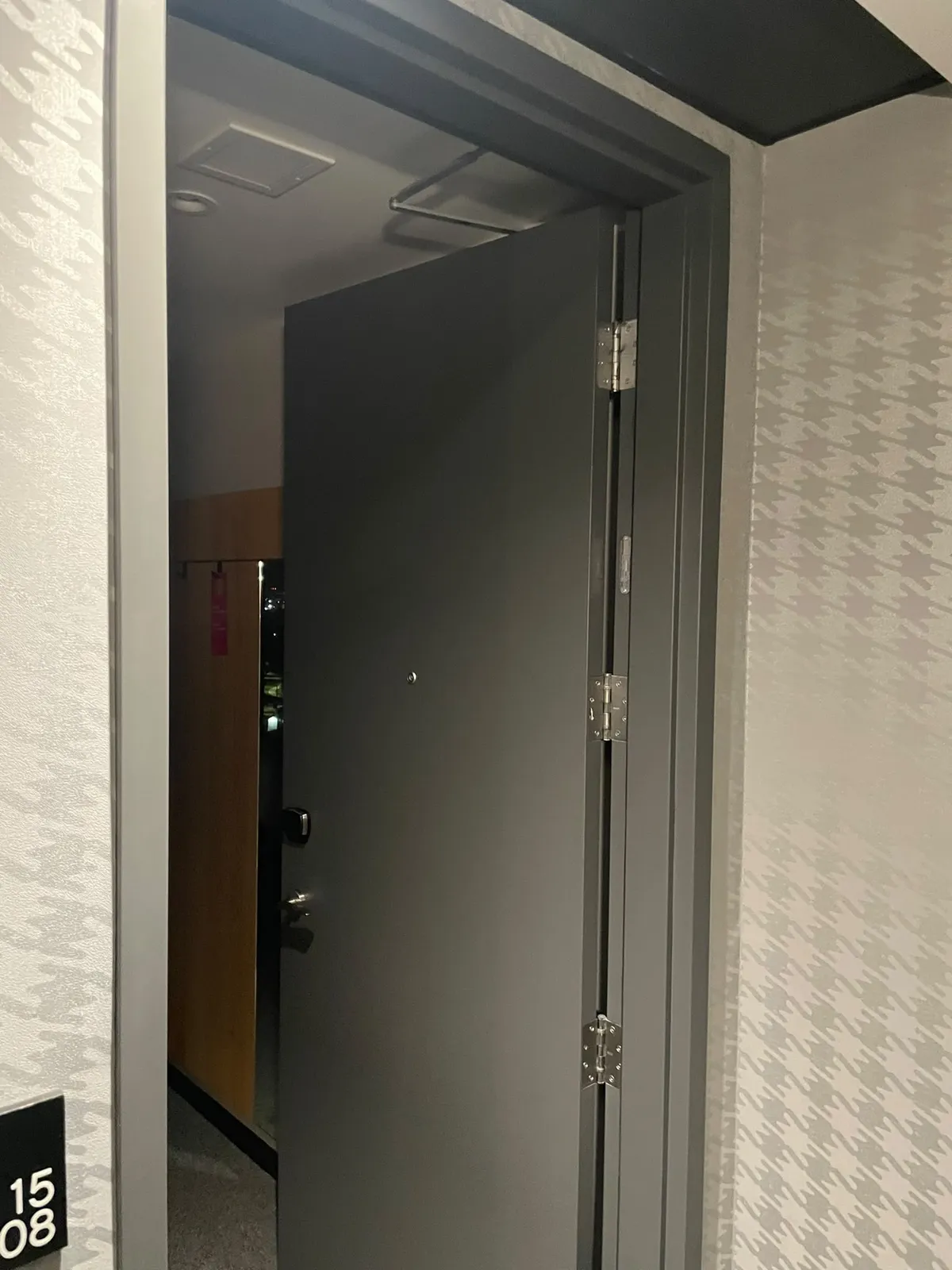 Guest room door open at Alt Hotel Saskatoon showing the room number plaque