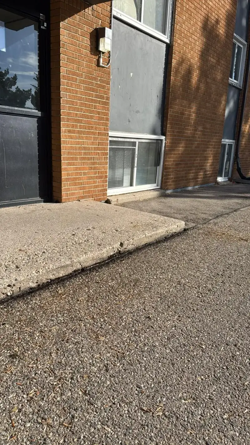 Rear concrete apron meeting the asphalt with the joint sealed