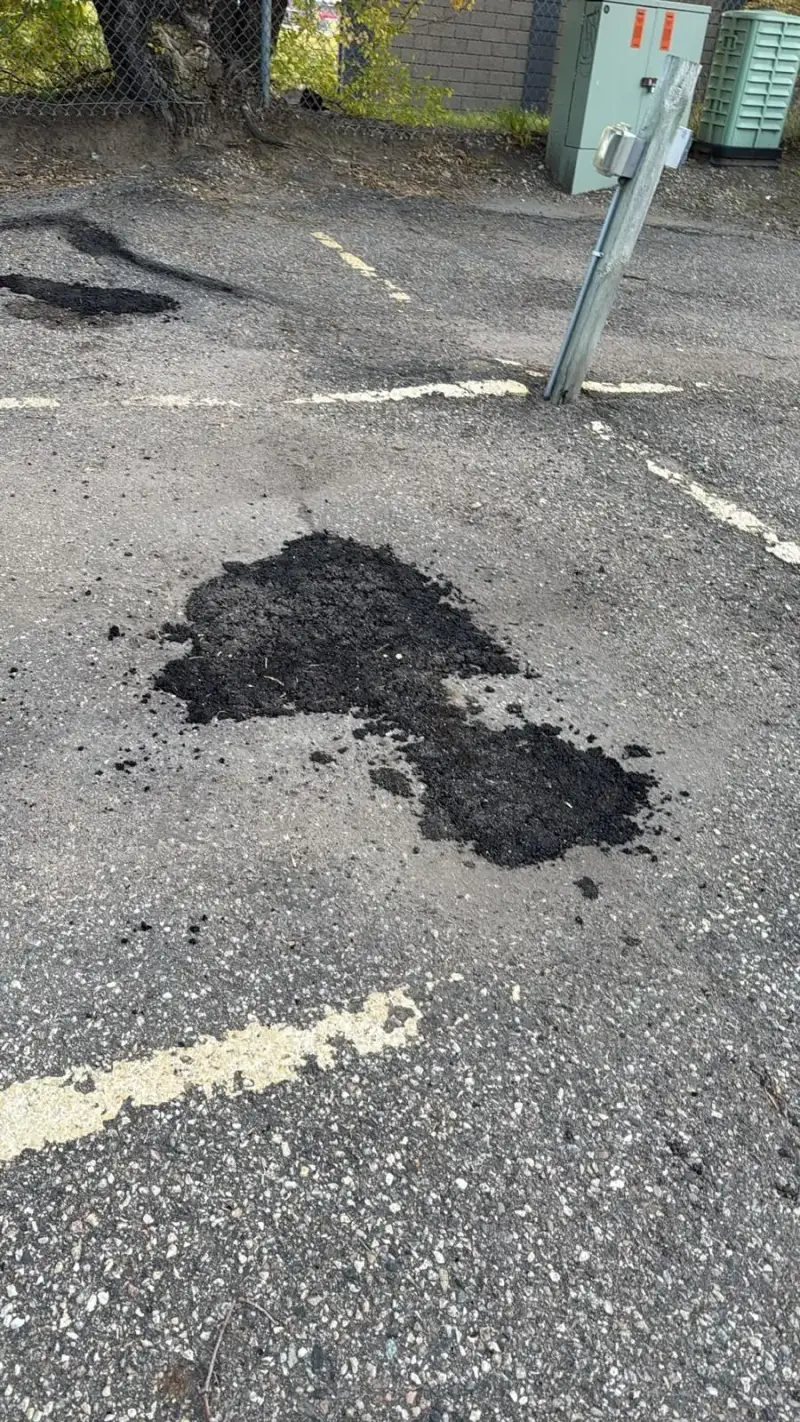 Hot-mix asphalt patches between painted parking stall lines